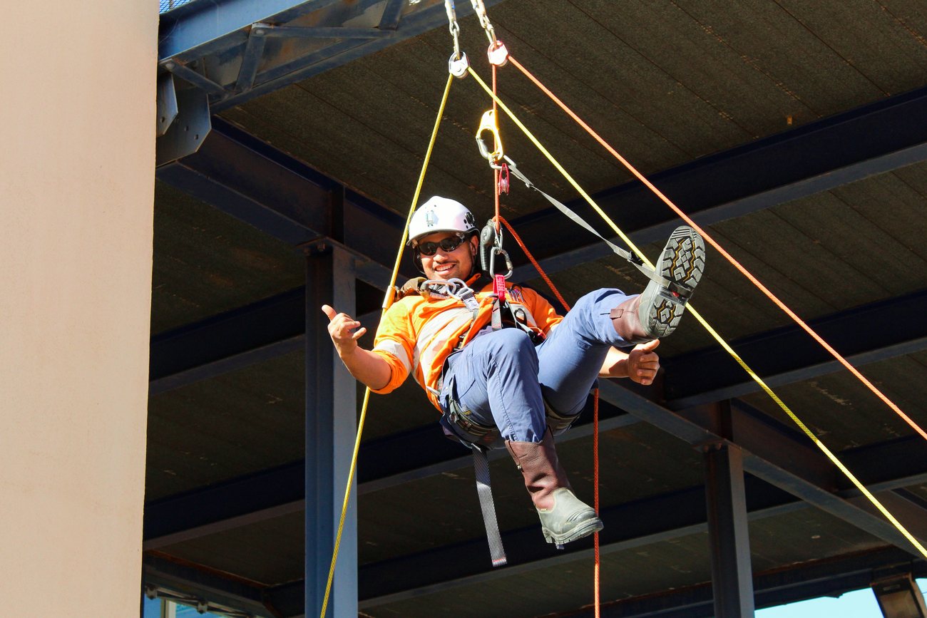 A responder suspended on ropes during a rope rescue