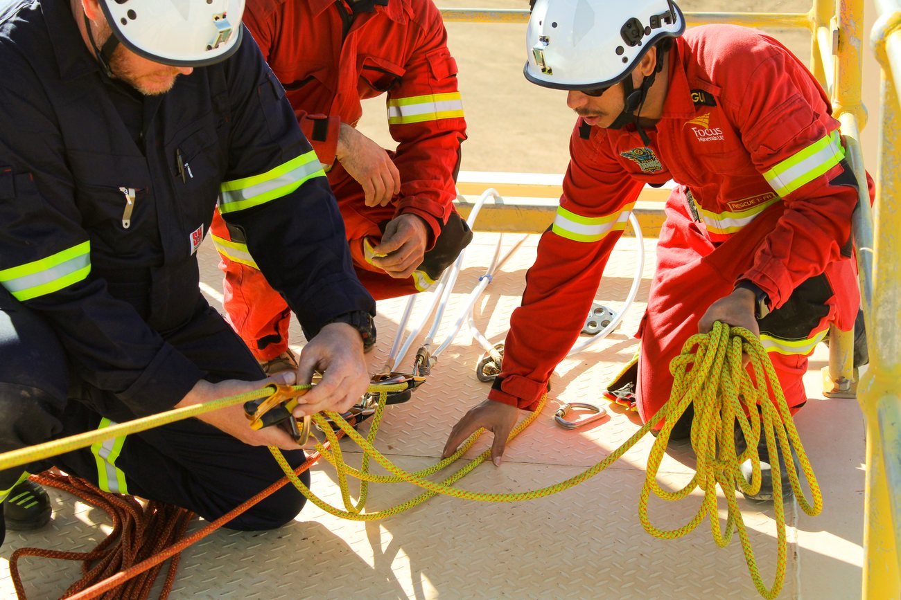 Responders rigging ropes and hardware together during a rescue